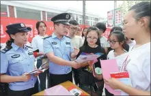  ?? WAN SHANCHAO / FOR CHINA DAILY ?? Police hand out pamphlets on financial risk awareness at a university in Huaibei, Anhui province.