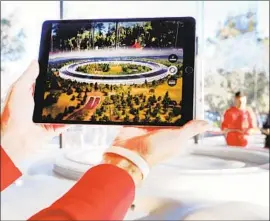  ?? Amy Osborne AFP/Getty Images ?? THE TECH GIANT, which boasts 130,000 full-time employees, gets workers from three dozen staffing firms. Above, an iPad shows the Apple Park in Cupertino.