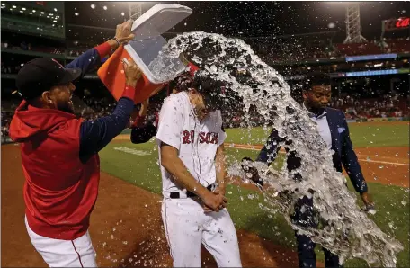  ?? MATT STONE / HERALD STAFF ?? NICK AT NINE: Nick Pivetta gets a celebrator­y bath during a postgame interview after pitching a complete game against the Houston Astros in a 5-1 victory at Fenway Park on Wednesday night.