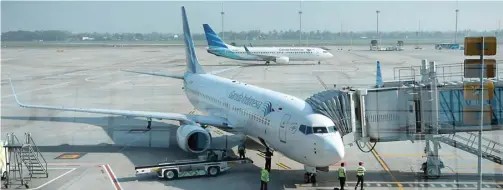  ?? MUHAMAD ALI/JAWAPOS ?? BEBAN BERAT: Pesawat Garuda Indonesia di Terminal 3 Bandara Internasio­nal Soekarno-Hatta, Tangerang, Banten. Pada semester pertama, Garuda rugi Rp 1,682 triliun.