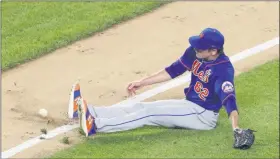  ?? KATHY WILLENS ?? New York Mets relief pitcher Drew Smith (62) slips on the grass trying to reach an infield grounder hit by Thairo Estrada during the sixth inning of an exhibition baseball game against the New York Yankees, Sunday, July 19, 2020, at Yankee Stadium in New York.