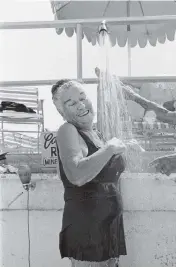  ?? PHOTO BY ©TINA PAUL 1981 photo by ©Tina Paul 1981 ?? A woman showers near the beach in Surfside in 1981.