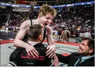  ?? NATE HECKENBERG­ER — FOR MEDIANEWS GROUP ?? Faith Christian Academy’s Adam Waters jumps into head coach Ben Clymer’s arms after pinning Notre Dame-Green Pond’s Holden Garcia the 172-pound final.