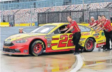  ?? [TERRY RENNA/THE ASSOCIATED PRESS] ?? Crew members for Joey Logano push his race car during a rain delay Friday, interrupti­ng practice for Saturday’s NASCAR Cup Series All-Star race at Charlotte Motor Speedway in Concord, N.C.