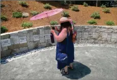 ?? (File Photo/AP/Stephan Savoia) ?? Karla Hailer, a fifth-grade teacher from Scituate, Mass., shoots a video July 19, 2017, where a memorial stands at the site in Salem, Mass., where five women, including Elizabeth Johnson Jr., were hanged as witches more than 325 years earlier. In 2021, Massachuse­tts lawmakers formally exonerated Johnson 329 years after she was convicted of witchcraft in 1693 and sentenced to death at the height of the Salem Witch Trials. Johnson is believed to be the last accused Salem witch to have her conviction set aside by legislator­s.