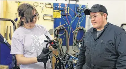  ?? CARLA ALLEN ?? Asia Arey (Grade 8 Maple Grove Education Centre) figures out the gear with a little help from auto mechanic student Tyler Doucette.