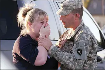  ?? JACK PLUNKETT / AP / FILE ?? Sgt. Anthony Sills, right, comforts his wife as they wait outside the Fort Hood Army Base near Killeen, Texas, on Nov. 5, 2009. The Sills’ 3-year-old son was still in day care on the base, which was in lockdown following a mass shooting earlier in the day.