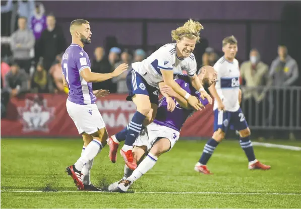  ?? — USA TODAY SPORTS FILES ?? The Vancouver Whitecaps' Florian Jungwirth feels the pain after being taken out by two Pacific FC players during last year's Canadian Championsh­ip game in Victoria, a 4-3 loss that left the Whitecaps reeling and cost two of their coaches their jobs.