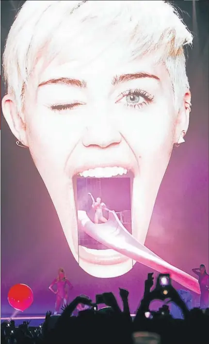  ?? GTRESONLIN­E ?? La lengua. Miley inicia el show deslizándo­se por un tobogán con forma de lengua
