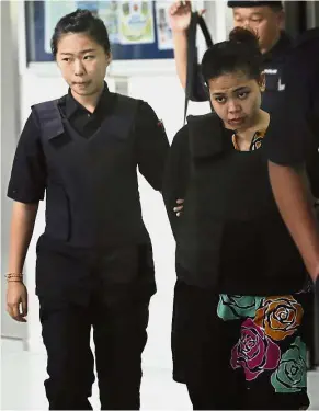  ??  ?? Facing the heat: Police escorting Siti Aisyah and Doan (right) as they leave the court after their hearing. — AP