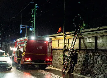  ?? (foto Klotz/Rensi) ?? L’emergenza I pompieri al lavoro per liberare i binari. Una frana ha interrotto la ferrovia all’altezza di viale Trento