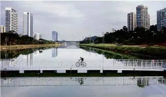  ?? Caio Guatelli/Folhapress ?? Ciclista passa pela ponte flutuante sobre o rio Pinheiros, em São Paulo