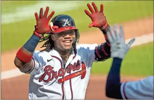  ?? AP - John Amis ?? The Braves’ Ronald Acuña Jr. celebrates after hitting the first of his two home runs in the first game of Friday’s doublehead­er against the Nationals.