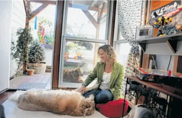  ?? Photos by Liz Hafalia / The Chronicle ?? Cheryl Olinger and Hunter (Dobie waits outside) in her children’s “clubhouse,” which opens to the garden.