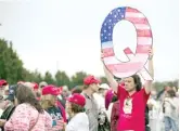  ?? AP FILES ?? A man holds a QAnon sign in 2018 while waiting to enter a campaign rally for President Donald Trump in Wilkes-Barre, Pa.