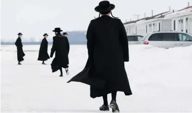  ?? DAVE CHIDLEY/ THE CANADIAN PRESS ?? Members of the Lev Tahor ultra-Orthodox Jewish sect walk down a street while an emergency motion in the child custody case was held at the courthouse in Chatham, Ont., on Wednesday.