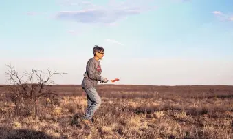  ?? ROBERTO E. ROSALES/JOURNAL ?? Grouse biologist Tish McDaniel picks up markers on the open prairie east of Portales after providing conservati­onists and media an opportunit­y to see lesser prairie chickens gather in the spring to find a mate.