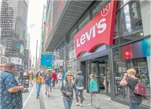  ?? AP ?? People walk past the Levi’s store in New York’s Times Square.