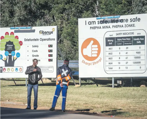  ?? MUJAHID SAFODIEN / AFP / GETTY IMAGES ?? Signs stand at the entrance to the South African Sibanye-Stillwater Driefontei­n gold mine, where an earthquake in May claimed a total of seven lives, its owner said. The gold is found mostly in narrow reefs that dip at angles, getting progressiv­ely deeper after 130 years of mining.