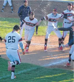  ?? GARY MIDDENDORF/DAILY SOUTHTOWN ?? St. Rita’s Al Holguin (25) is greeted by a shower from his teammates after hitting a walk-off two-run homer in the bottom of the seventh inning.