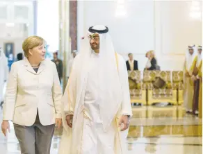 ?? (Reuters) ?? CROWN PRINCE of Abu Dhabi Sheikh Mohammed bin Zayed al-Nahyan walks with German Chancellor Angela Merkel in Abu Dhabi on Monday.
