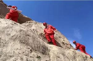  ??  ?? 中国石化工作人员跋山­涉水，为贫困地区村民勘查自­来水线路。