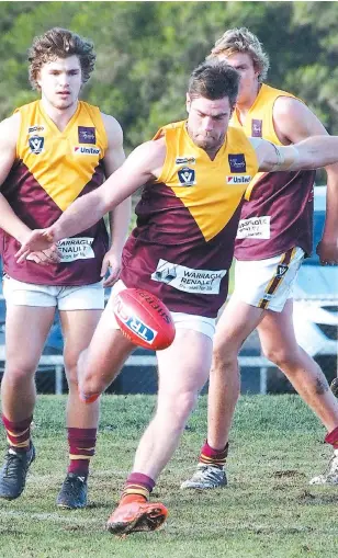  ??  ?? Steve Ballingall, one of Drouin’s most consistent players this year, wins a centre clearance and kicks his side into attack at Traralgon on Saturday. At rear are Liam Axford and Brad Williams.