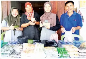  ??  ?? ADZMIN (kanan) merakam gambar bersama para penjaja bazar Ramadan Kg. Lohan Satu.