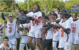  ?? KARL MERTON FERRON/BALTIMORE SUN ?? Poly players celebrate with the championsh­ip plaque after beating City, 17-3, to win the Baltimore City championsh­ip at Frederick Douglass High on Monday.
