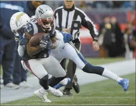  ?? AP photo ?? Patriots wide receiver Phillip Dorsett catches a pass as Chargers cornerback Michael Davis defends during the first half Sunday in Foxborough, Mass.