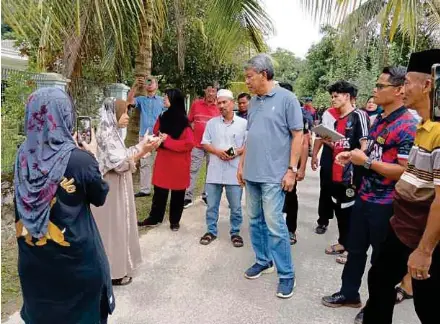  ?? (Foto Mohd Amin Jalil/bh) ?? Mohamad ketika melawat mangsa banjir kilat di Kampung Paroi, Seremban, kelmarin.