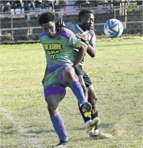  ?? (Photo: Paul Reid) ?? Treasure Beach FC’S Ferron Messam (left) is challenged by Falmouth United’s Kevin Laing in their JFF Tier II game at Elleston Wakeland Centre, recently. Falmouth United won 2-0.