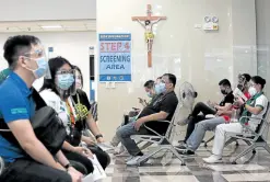  ?? —MARIANNE BERMUDEZ ?? UPTREND Health workers await their turn to be inoculated against COVID-19 at Dr. Jose Fabella Memorial Hospital in Manila on Friday. The Department of Health reported the second highest daily uptick in infections since October last year.