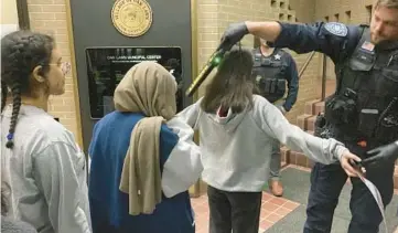  ?? KIMBERLY FORNEK/DAILY SOUTHTOWN ?? Police used a metal-detecting wand to check for weapons on people attending the Oak Lawn Fire & Police Commission meeting March 1.