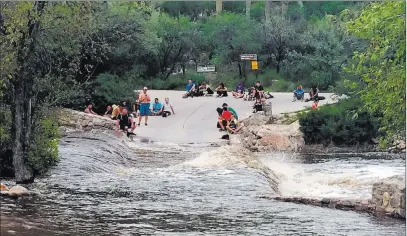  ??  ?? The Associated Press Hikers stranded by flash flooding Sunday in the Sabino Canyon Recreation Park in the outskirts of Tucson, Ariz. A police helicopter rescued approximat­ely 35 hikers stranded by the flooding 15 days after 10 people died in flash...