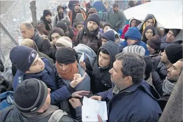  ?? Petros Giannakour­is Associated Press ?? POLICE CHECK registrati­on papers as refugees try to cross from Greece into Macedonia last year. An estimated 885,000 migrants — or 40% of the 2.2-million total in 2015 and 2016 — won asylum in Europe.