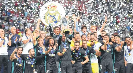  ??  ?? Real Madrid's players celebrate with the trophy after winning the UEFA Super Cup football match against Manchester United at the Philip II Arena in Skopje. Real Madrid won the match 2-1