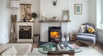  ??  ?? Above left The living room is part of the open-plan living space. The stove is Yotel, and the mantlepiec­e above it from The Store Yard, Portlaoise, as are the antique oars. The white shade is from AY Illuminate. The floors were rotten when Emma and her...