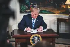  ?? Bloomberg ?? Trump signs a Presidenti­al Memorandum on Iran at the White House on Tuesday.