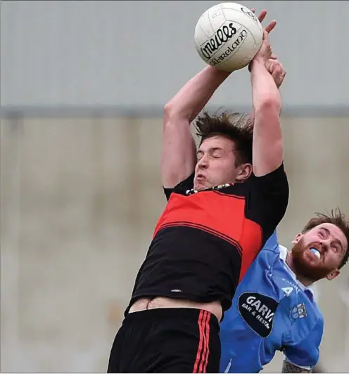  ??  ?? Dreadnots’ Liam Shevlin looks to gather a high delivery under pressure from Newtown Blues’ Alan Curran. Picture:Colin Bell