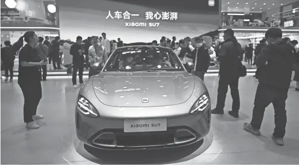  ?? PEDRO PARDO/AFP VIA GETTY IMAGES ?? The new Xiaomi SU7 is displayed at this year’s Beijing auto show.