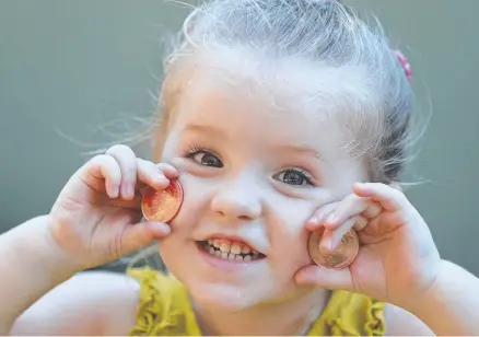  ?? Picture: ANNETTE DEW ?? Esme Moeller, 3, has fun with the copper coins, which are part of the Anzacs: Medals of Honour collection.