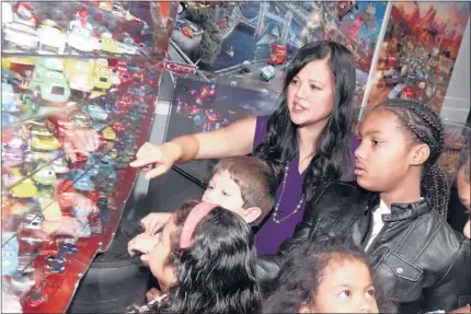  ?? CASEY RODGERS/ASSOCIATED PRESS ?? Mattel executive Jean Gomez discusses Mattel’s rare die- cast collection with kids at the launch of the “From Silver Screen to Die- Cast: Disney- Pixar Cars Imagined by Mattel” exhibit at the Petersen Automotive Museum in Los Angeles.