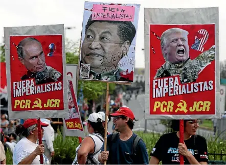  ?? AP ?? Protesters with signs depicting, from left, Russian President Vladimir Putin, Chinese President Xi Jinping and US President Donald Trump, with the Spanish phrase ‘‘Get out imperialis­ts!’’, march against the Group of 20 summit in Buenos Aires.