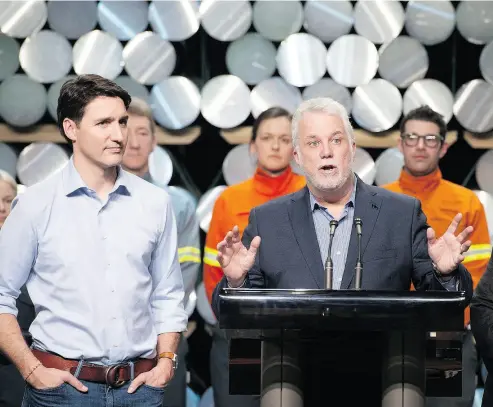  ?? JACQUES BOISSINOT / THE CANANDIAN PRESS ?? Prime Minister Justin Trudeau, left, and Quebec Premier Philippe Couillard meet with workers during a visit to the Rio Tinto AP60 aluminum plant in Saguenay, Que., on Monday. Trudeau is on a tour of Canadian metal factories.