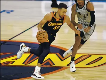  ?? PHOTOS BY NHAT V. MEYER — BAY AREA NEWS GROUP ?? The Golden State Warriors’ Stephen Curry (30) dribbles against the San Antonio Spurs’ Dejounte Murray (5) in the second quarter at the Chase Center in San Francisco on Wednesday.