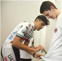  ?? Photo by Shihab ?? UAE cyclist Yousif Mirza signing autographs for his fans during the launch of the UAE Team Emirates Youth Academy at DWTC on Tuesday. —