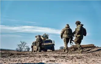  ?? Libkos/Associated Press ?? Ukrainian soldiers approach their armored U.S. Hummer in position Saturday near Bakhmut, Donetsk region, Ukraine. The Donetsk province is one of the key areas Russia hopes to control.