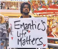  ?? KIM CHANDLER/ASSOCIATED PRESS ?? Elijah King holds a sign Saturday during a protest at the Riverchase Galleria mall in Hoover, Ala., over the police shooting of Emantic Fitzgerald Bradford Jr.