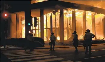  ?? NELVIN C. CEPEDA U-T FILE ?? Deputies set up a perimeter around the Chase Bank on Spring Street in La Mesa on May 30 after demonstrat­ors broke the glass to gain entry to the bank and eventually set it on fire.